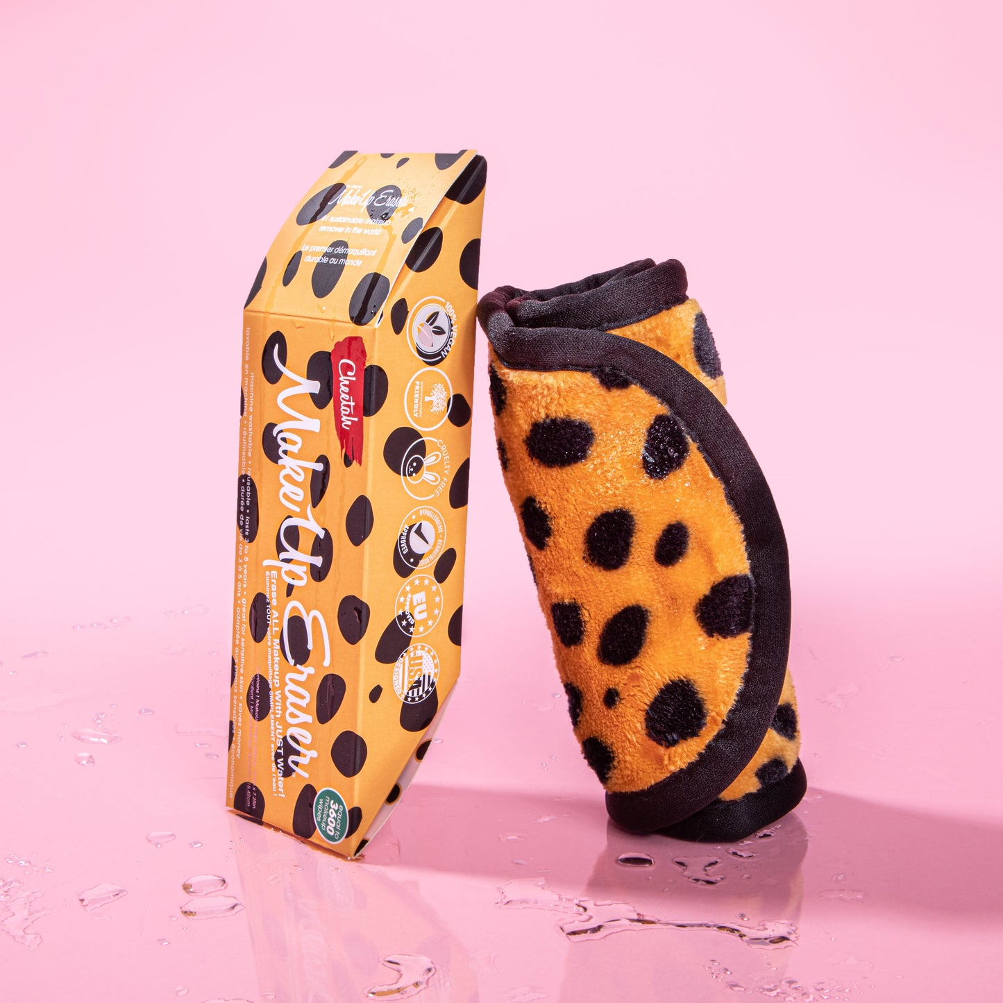 Rolled up Cheetah Print MakeUp Eraser next to packaging surrounded by waterdrops.