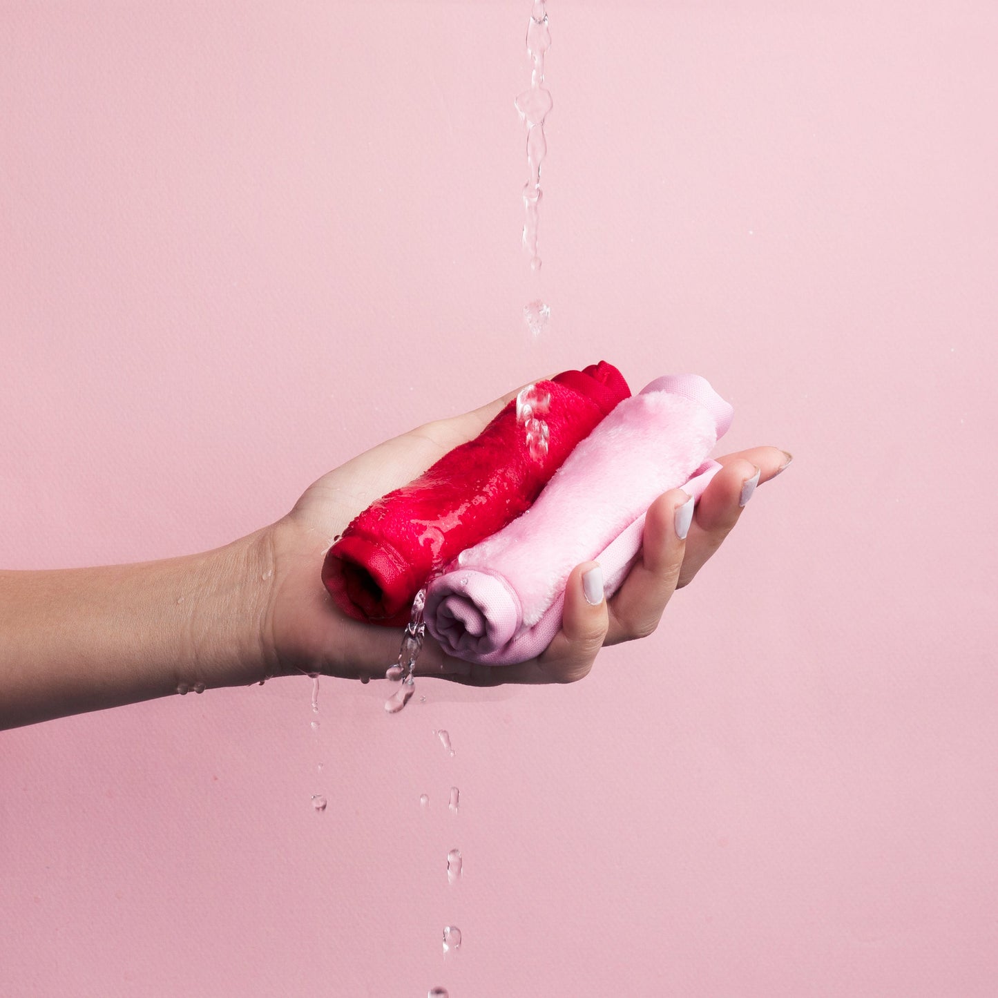 Naughty & Nice 2pc Minis MakeUp Eraser cloths rolled up in someone's hand.