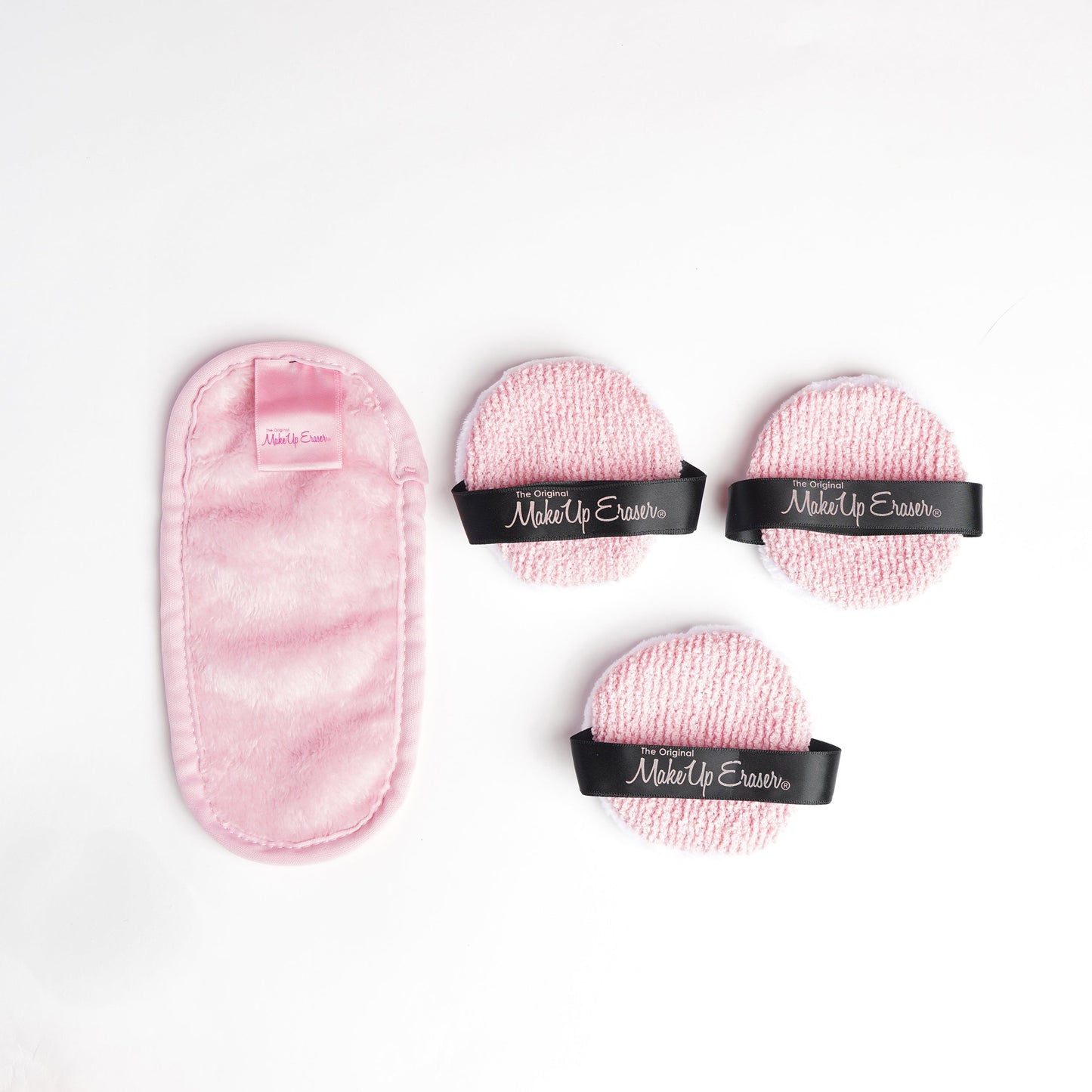 Mini Pink MakeUp Eraser next to 3 The Puff cloths.