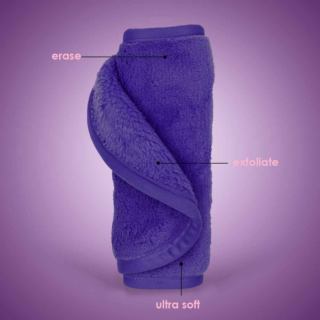 Rolled up Queen Purple MakeUp Eraser with both sides exposed. The short fiber side is labeled as erase, and the long fiber side is labeled as exfoliate.