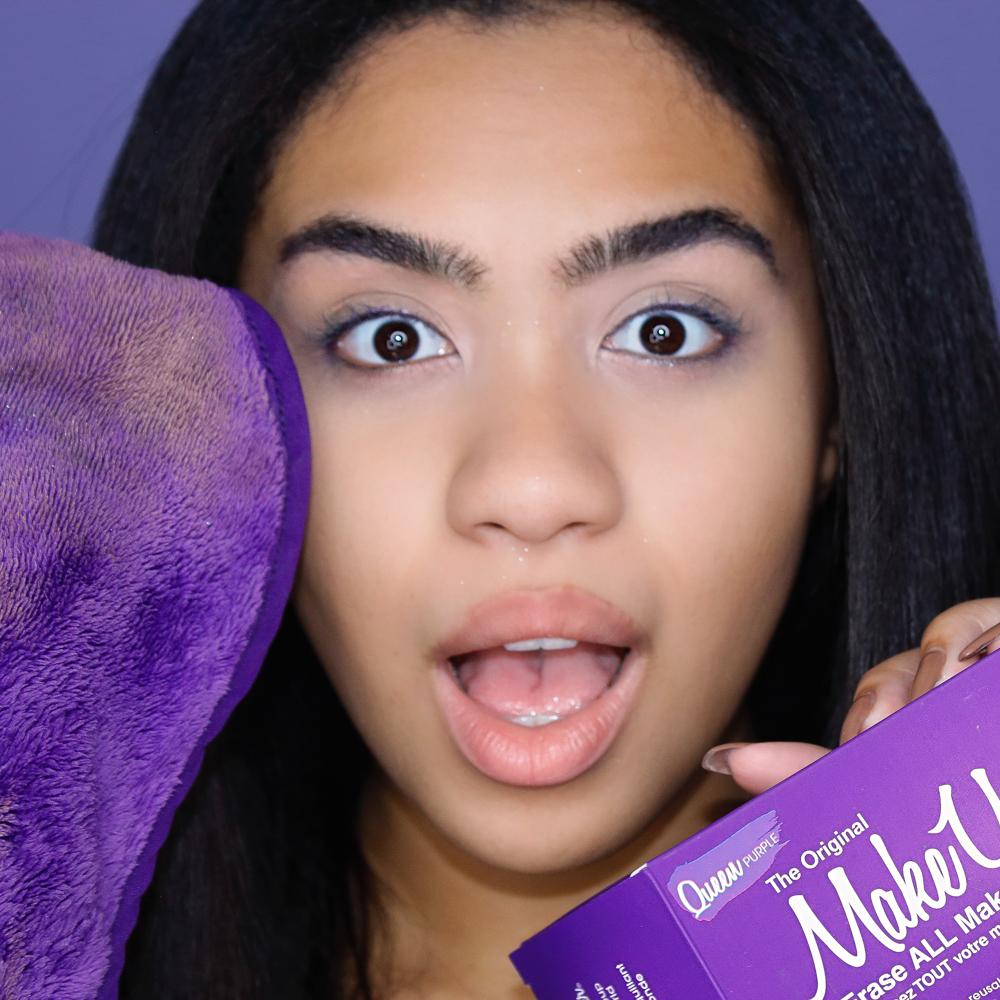 Woman holding up Queen Purple MakeUp Eraser cloth and packaging.