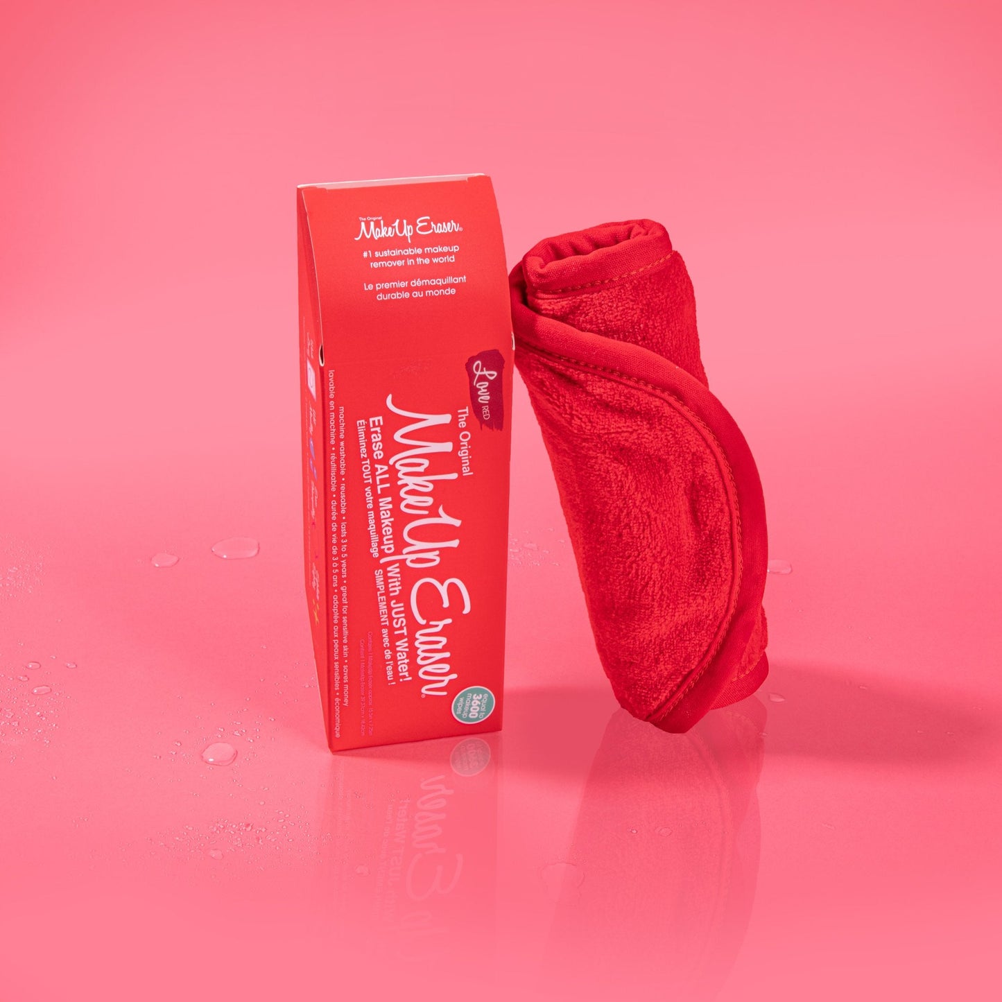 Rolled up Love Red MakeUp Eraser cloth next to packaging.